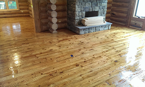 A living room with a rough cut wood flooring