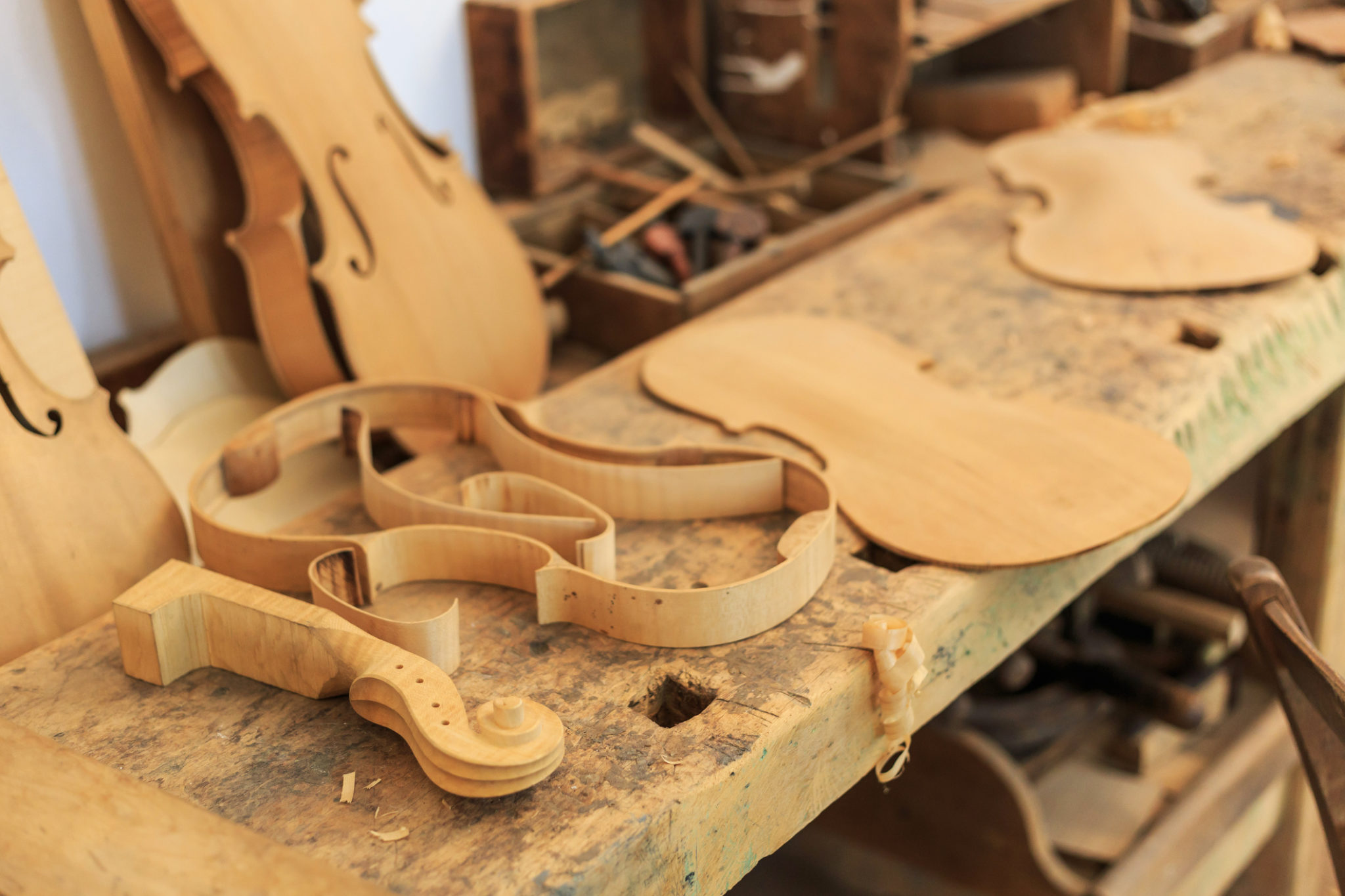 Unfinished violin and wooden tools in workshop – Superior Hardwoods